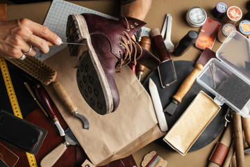 Enjoying process of creation custom made shoes. Workplace of shoe designer. Hands of shoemaker...
