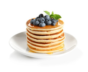 Plate with pancakes and berries on white background