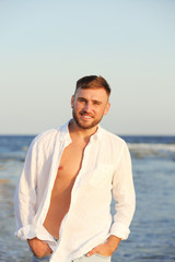 Fototapeta na wymiar Young man enjoying sunny day on beach