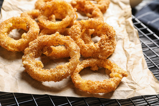 Cooling rack with homemade crunchy fried onion rings, closeup