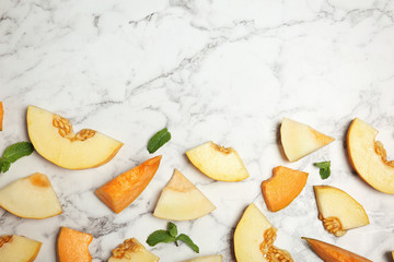 Flat lay composition with cut tasty melons on table. Space for text