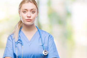 Young blonde surgeon doctor woman over isolated background with serious expression on face. Simple...