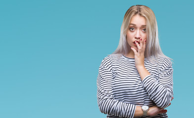 Young blonde woman over isolated background looking stressed and nervous with hands on mouth biting nails. Anxiety problem.