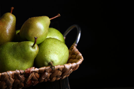 Tray with ripe pears on table against dark background, closeup. Space for text