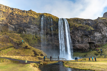 Seljalandsfoss, Iceland - Oct 22th 2017 - Tourists enjoying the Seljalandsfoss fall in a overcast day in Iceland.