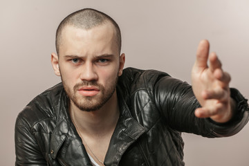 unshaven guy in trendy jacket proving adverse with gestures