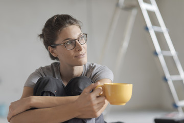 Woman doing a home renovation and having a coffee break