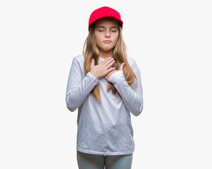 Young beautiful girl wearing red cap isolated background smiling with hands on chest with closed eyes and grateful gesture on face. Health concept.