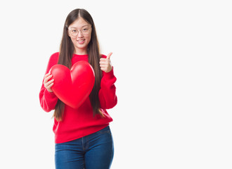 Young Chinese woman wearing graduate uniform red heart happy with big smile doing ok sign, thumb up with fingers, excellent sign