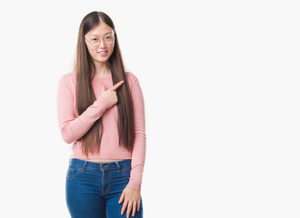 Young Chinese woman over isolated background wearing glasses cheerful with a smile of face pointing with hand and finger up to the side with happy and natural expression on face looking at the camera.