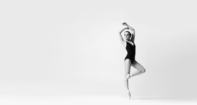 Young and beautiful ballerina dancing in studio.