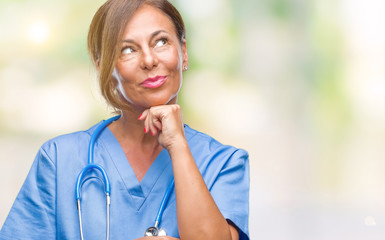 Middle age senior nurse doctor woman over isolated background with hand on chin thinking about question, pensive expression. Smiling with thoughtful face. Doubt concept.