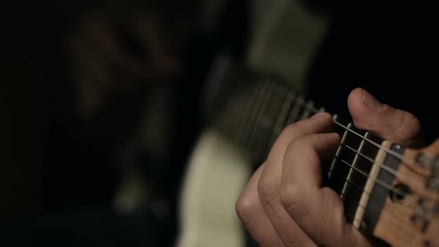 Close up shot of guitarist's hands plays chords on electric guitar