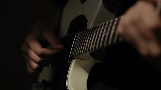 Close up shot of guitarist's hands plays chords on electric guitar