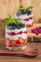Trifle close up photography with fresh multi layered dessert with dairy and ripe raspberries and...