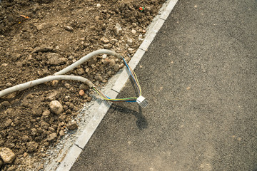 Electrical cables on sidewalk near construction site, conceptual image of human negligence.