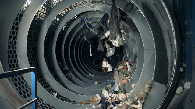 Lots of household waste being sorted in a machine for recycling.
