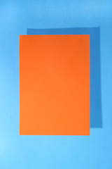 Sheet of orange paper on a blue background for decoration, for text design, for a template