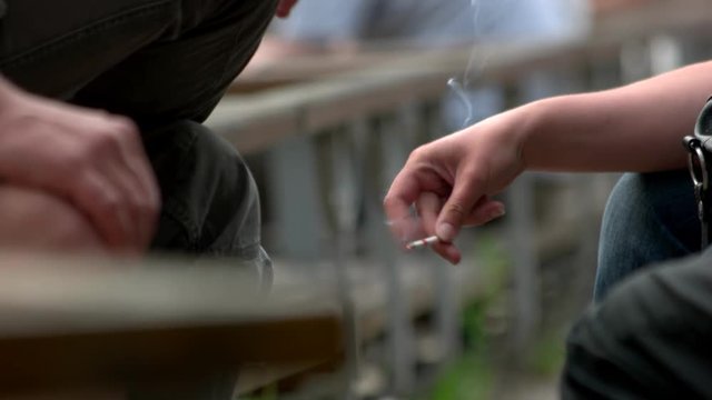 Two smoking people. Male and female hands with cigarettes, close up.