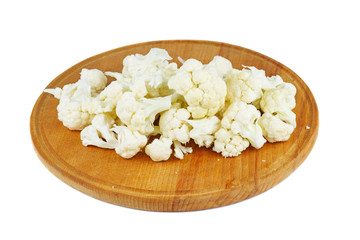 Cauliflower pieces on wooden cutting board isolated on white background