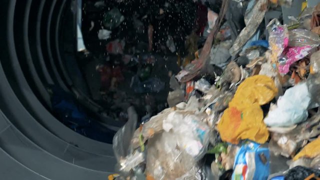 Big equipment sorts trash. Household garbage moves in a special machine to be sorted.