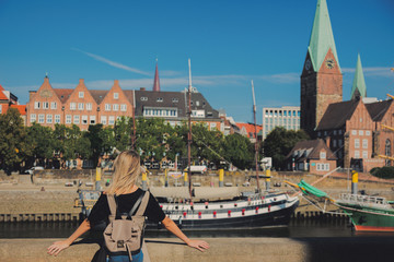 Young girl stay on a bridge with view at Bremen, Germany on background - obrazy, fototapety, plakaty
