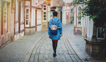 Fototapeta na wymiar Young lady in jeans jacket on medieval street of Bremen, Germany. Trevel destination concept