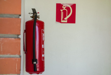 the fire extinguisher is suspended on the wall
