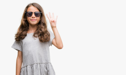 Brunette hispanic girl wearing sunglasses showing and pointing up with fingers number four while smiling confident and happy.