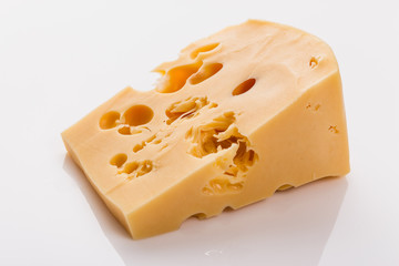 Piece and slices of cheese on a white background