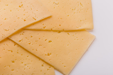 Piece and slices of cheese on a white background