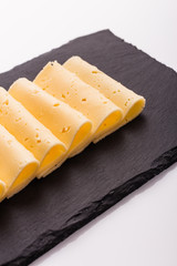 Piece and slices of cheese on a white background