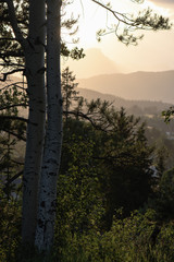 Sun peaks out from behind the clouds over Crowsnest Mountain and Seven Sisters Mountain