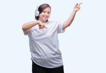 Young adult woman with down syndrome wearing headphones over isolated background smiling and...