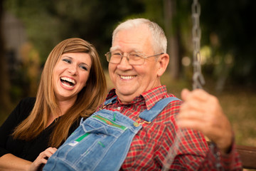 Grandfather and Granddaughter Laughing Together on Swing