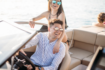 happy caucasian lovers taking a romantic trip on the motor boat, enjoying romantic atmosphere,...