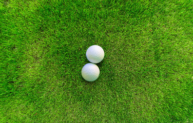 Two Golf Balls Lying on Green Grass View from Above
