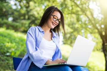 Young student Girl in eyesglasses resting and relaxing in the park and laptop.