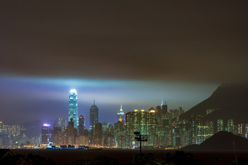 Storm Clouds hanging over Skyline of Hong Kong Central District with IFC Tower lighting the sky