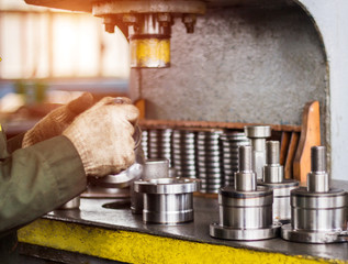 The worker assembles the pressing of the bearing into a metal clip on the machine, assembles the...