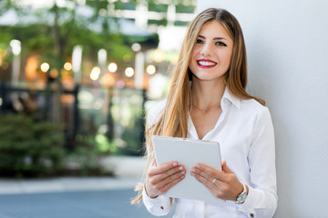 Smiling businesswoman using a digital tablet outdoor