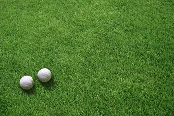 Two Golf Balls Lying on Green Grass View from Above