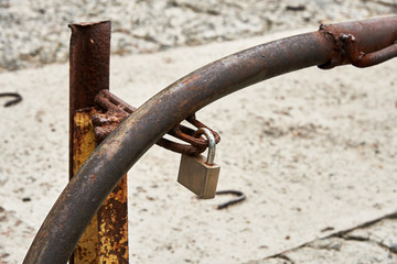 Rusty barrier is closed on a padlock