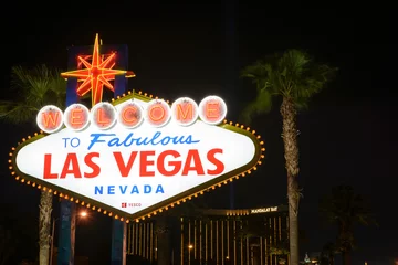 Fotobehang The Welcome To Las Vegas Sign At Night With Palm Trees In The Background © Mike