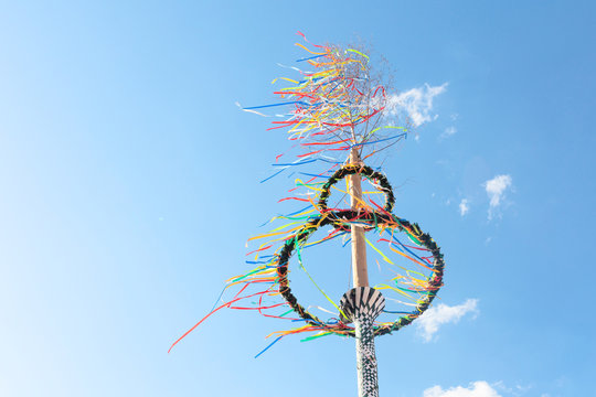 typical greman may pole or maibaum at the festival in front of blue sky, spring holiday concept