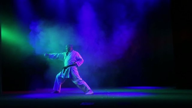 Master karate background with colored smoke performs kata
