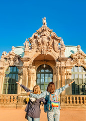 Woman Tourist couple friends with lgbt rainbow flag at Zwinger palace in Dresden, travel and love...