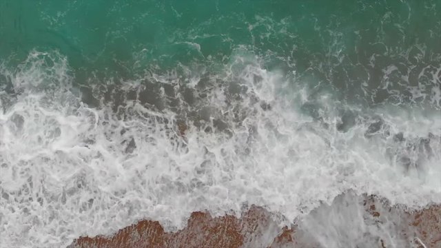 Sea foam, waves and azure clear water top aeria view. Spain, Valencian Country,  Province of Alicante,  Costa Blanca,  Benitachell, Cala del Moraig, Summer 2018