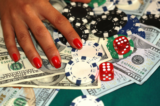 Woman playing craps with cash and chips on the green casino table