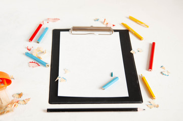 black tablet with blank pages, pencils on white background, creative writing concept. Minimalist...